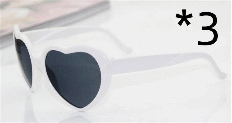 Heart-shaped glow-in-the-dark sunglasses in various vibrant colors, featuring a durable plastic frame and resin lenses for reliable UV protection.