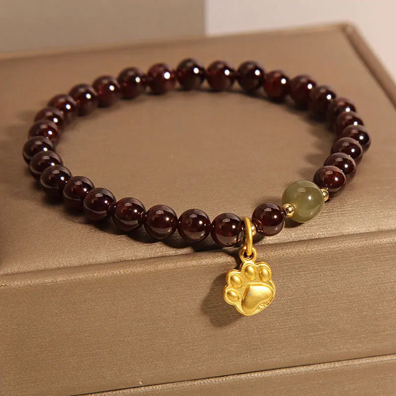 Women's crystal bracelet with a cat's paw garnet motif on a wrist.