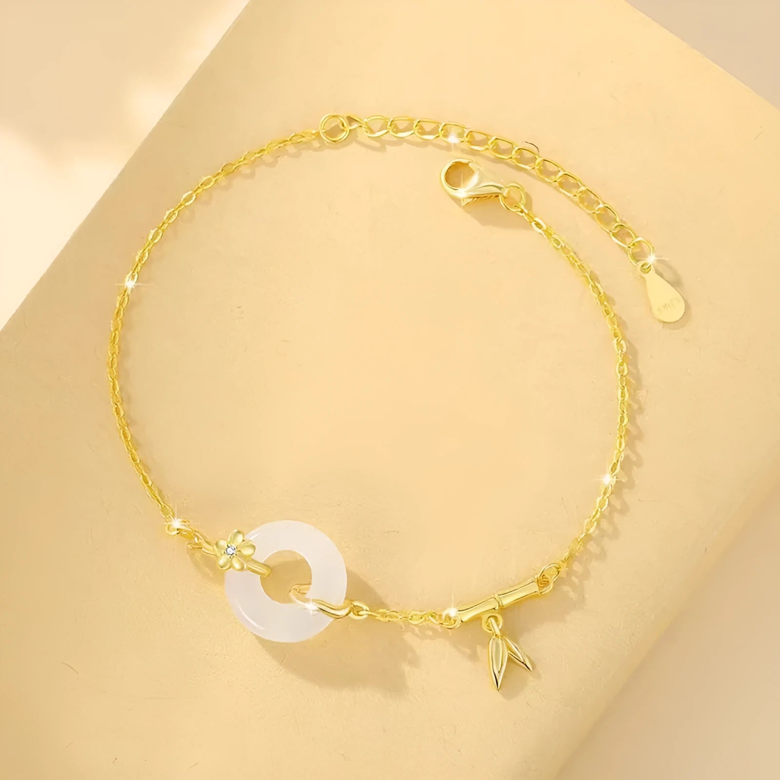 Gold tone women's bracelet with white chalcedony stone and adjustable peace symbol buckle closure