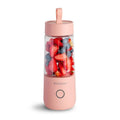 White portable USB blender bottle with silicone handle and stainless steel blade inside.