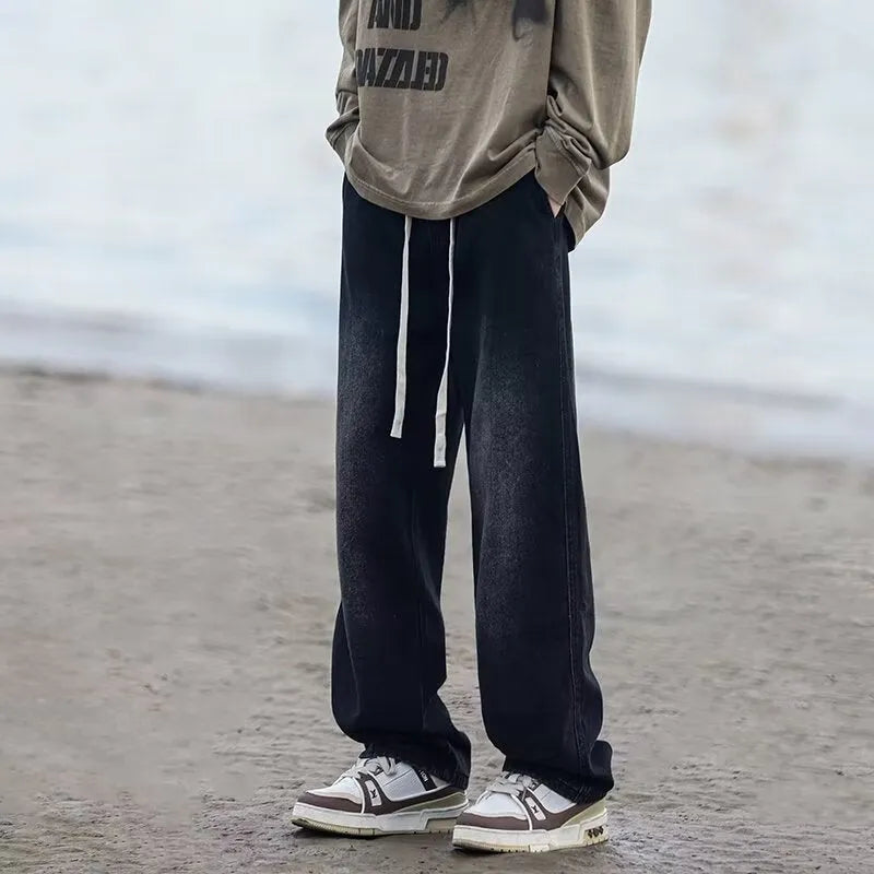 Men's loose fit straight leg denim trousers in blue and black with drawstring waist closure