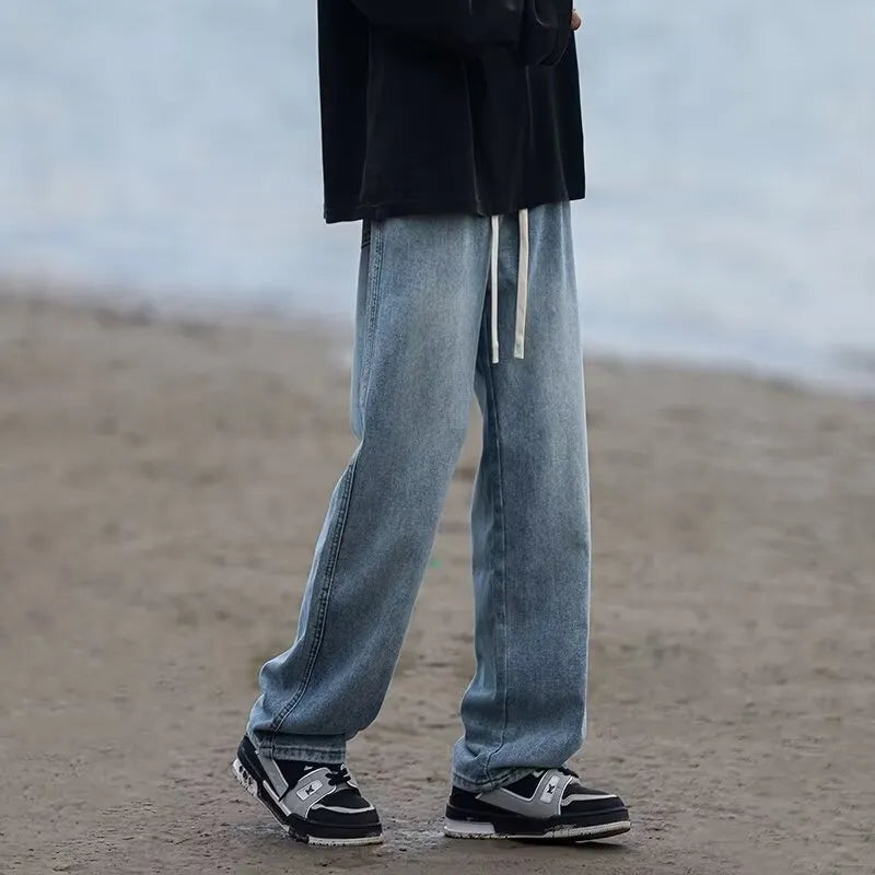 Men's loose fit straight leg denim trousers in blue and black with drawstring waist closure