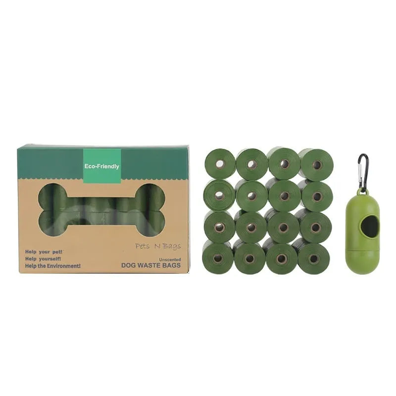 Roll of green EPI degradable pet waste bags next to a time capsule dispenser on a grass background.