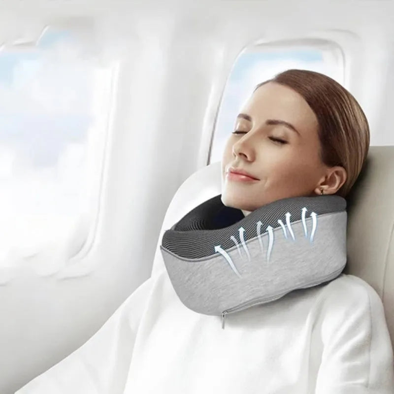 U-shaped navy blue travel neck pillow with memory foam, shown rolled up next to its carry bag.