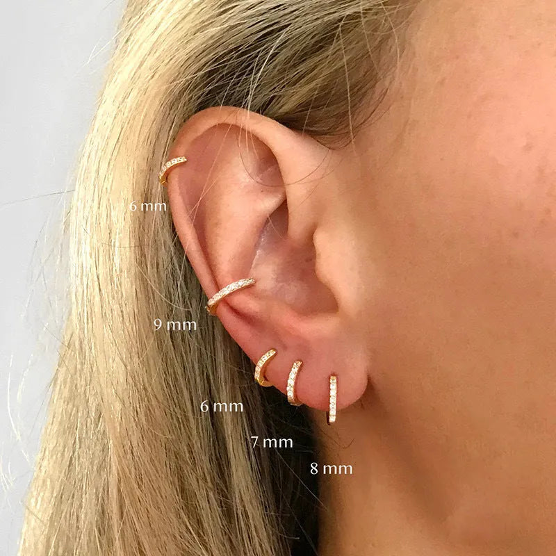 Perforated geometric circle stud earrings with zircon detail in gold, rose gold, and silver tones.