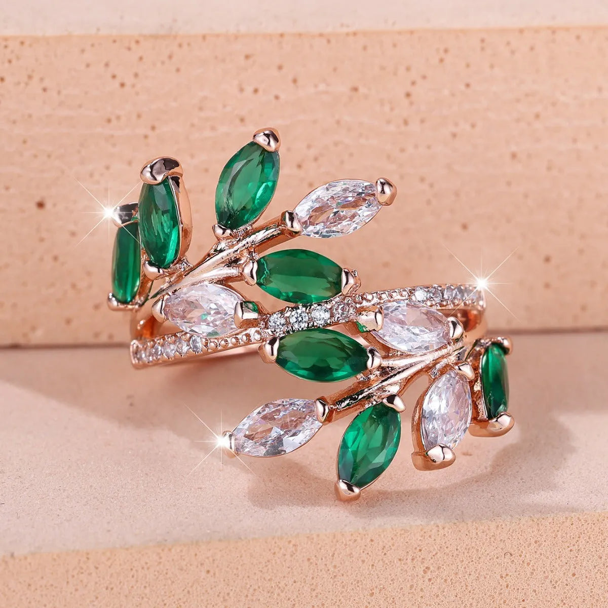 Adjustable copper leaf ring with a horse eye zircon stone in multiple colour finishes on a neutral background.