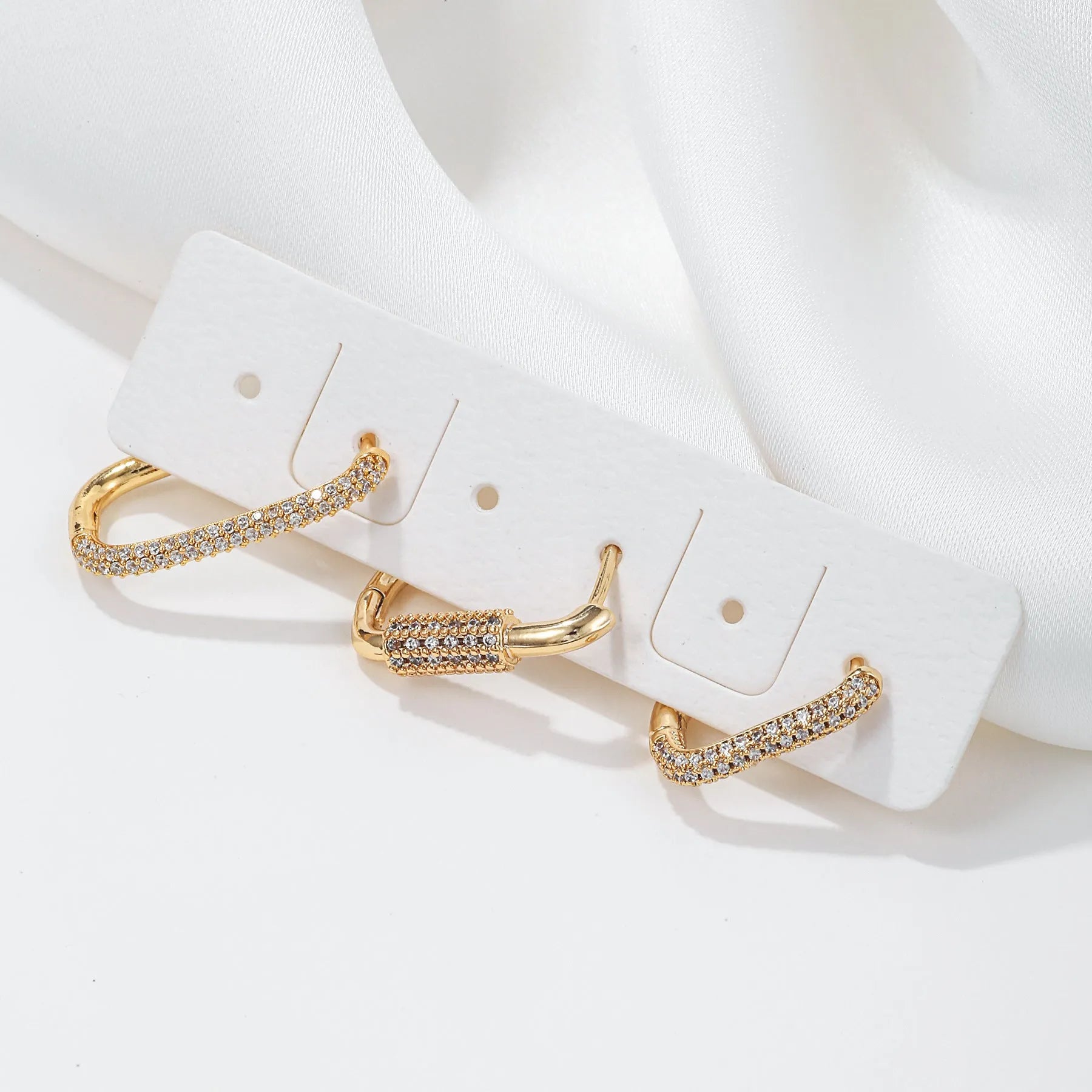 Set of three geometric square clip-on earrings with inlaid zircon detail in gold and white gold tones.