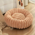 Soft beige rabbit plush round pet bed with high sides forming a nest, shown on a wooden floor.