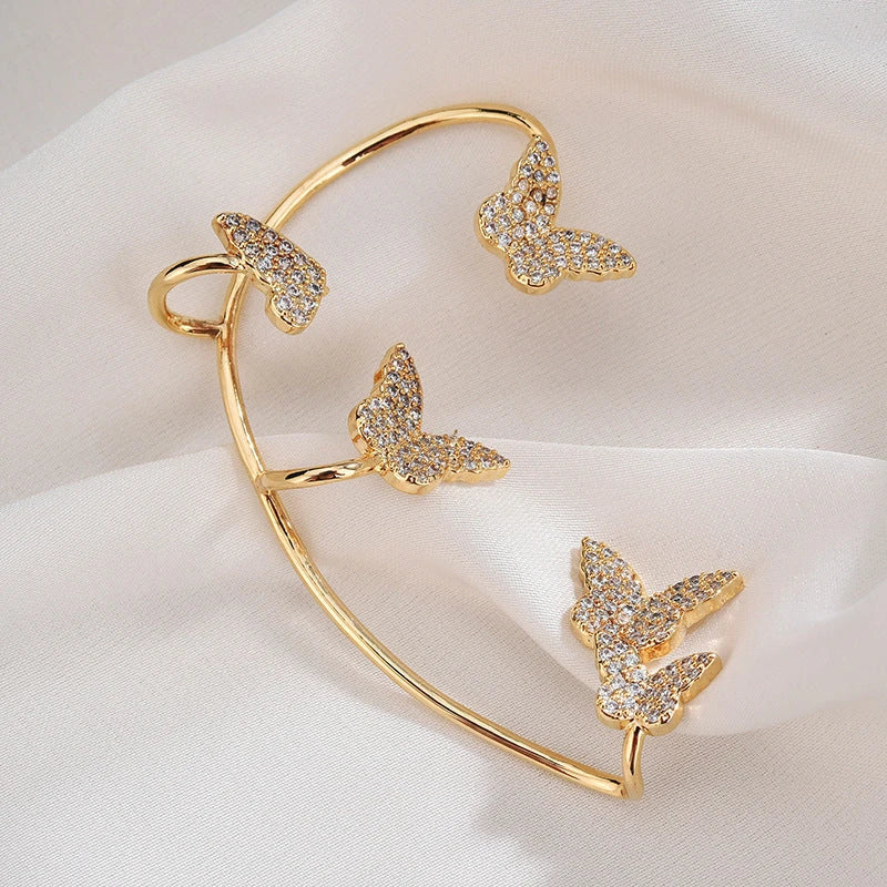 Sparkling zircon butterfly ear cuffs in gold-toned metal, featuring a delicate and elegant design for stylish accessorizing