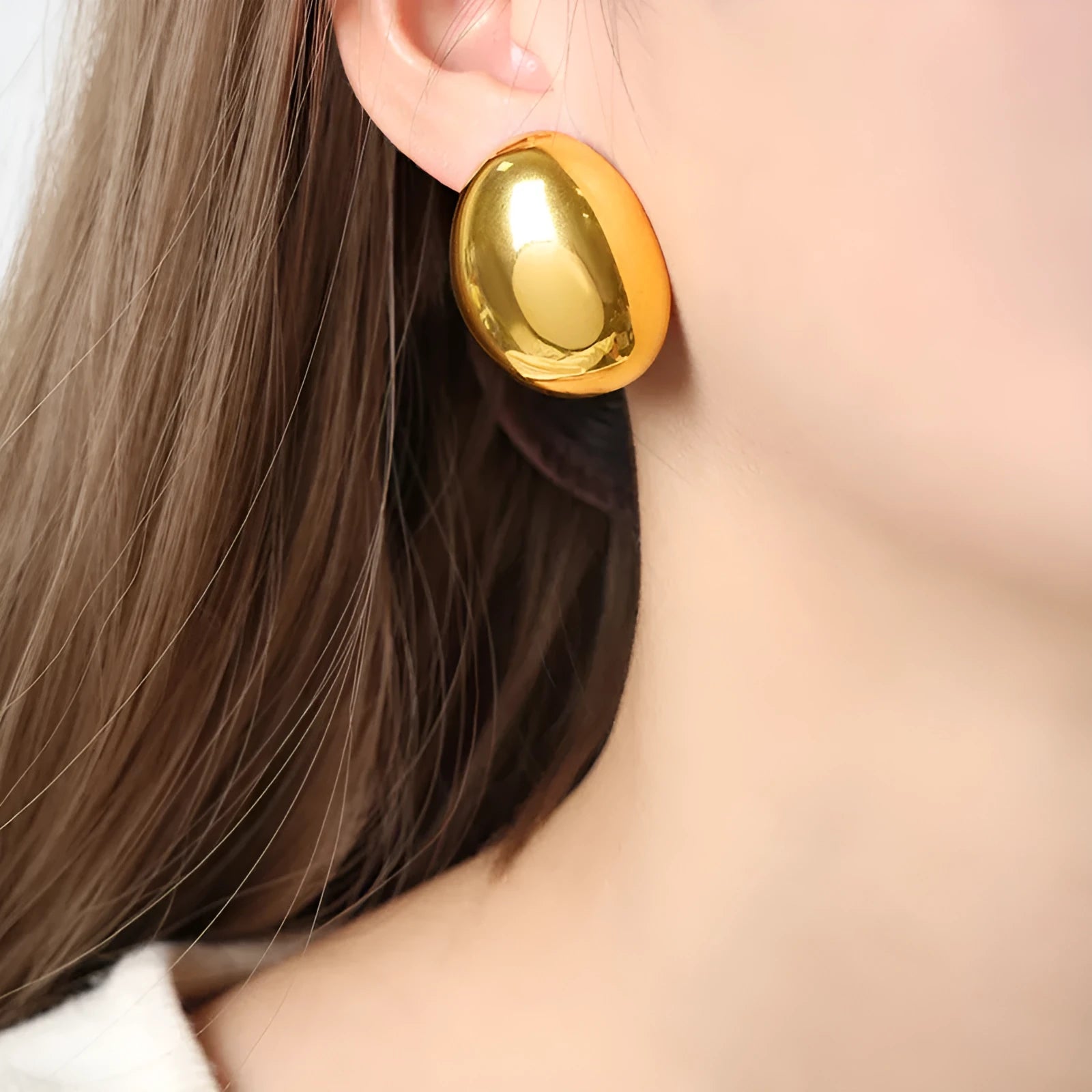 Geometric stainless steel ear studs with a gold electroplated finish and exaggerated glazed surface.