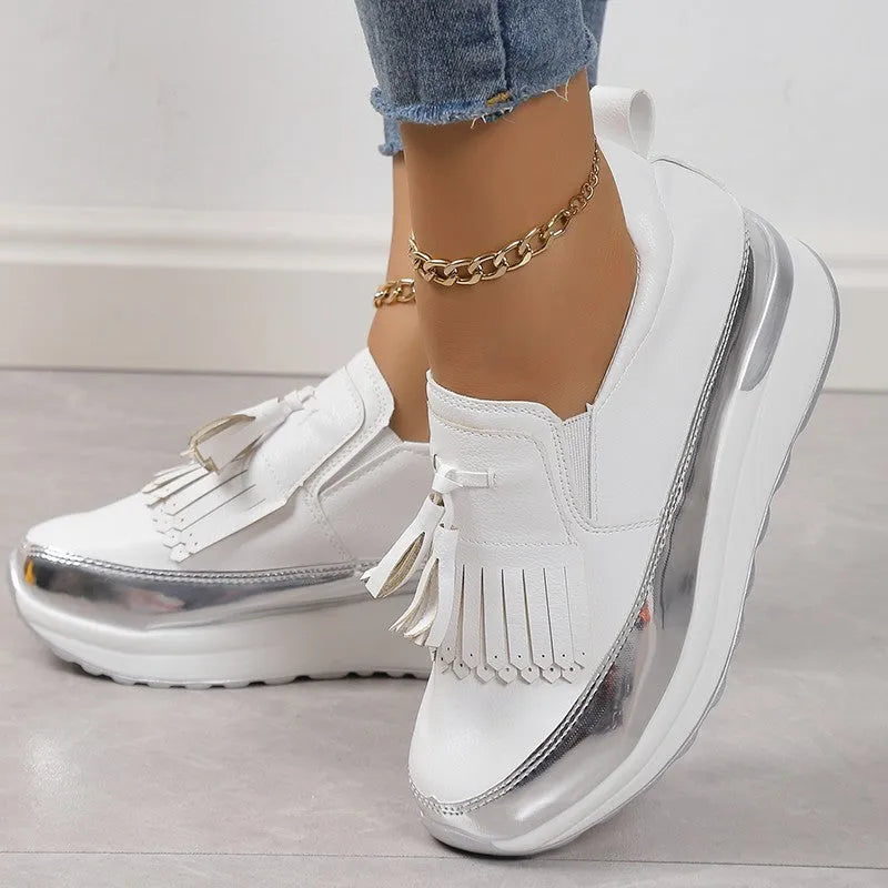 Women's black and white platform casual shoes with tassel detail and a muffin wedge heel
