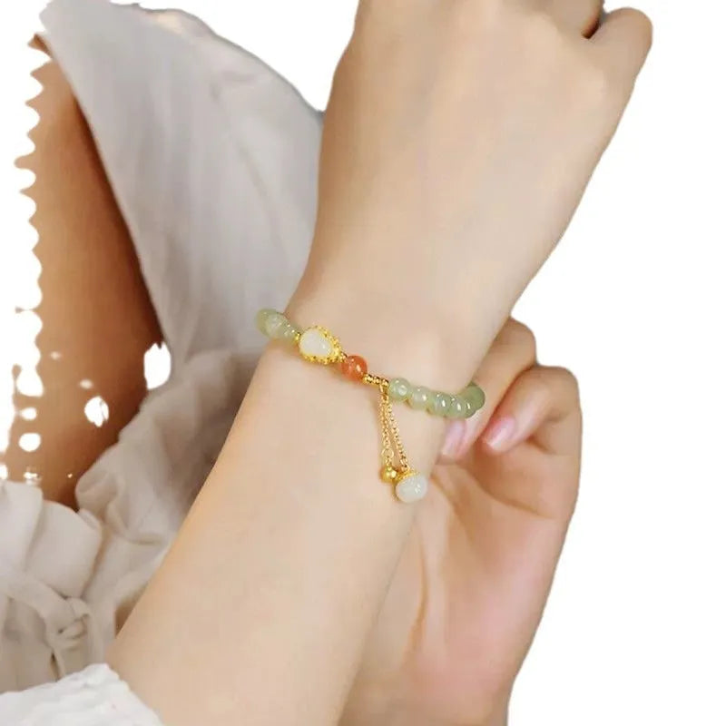 Women's jade bracelet with a 6mm gold-plated gourd charm and engraved fu character.