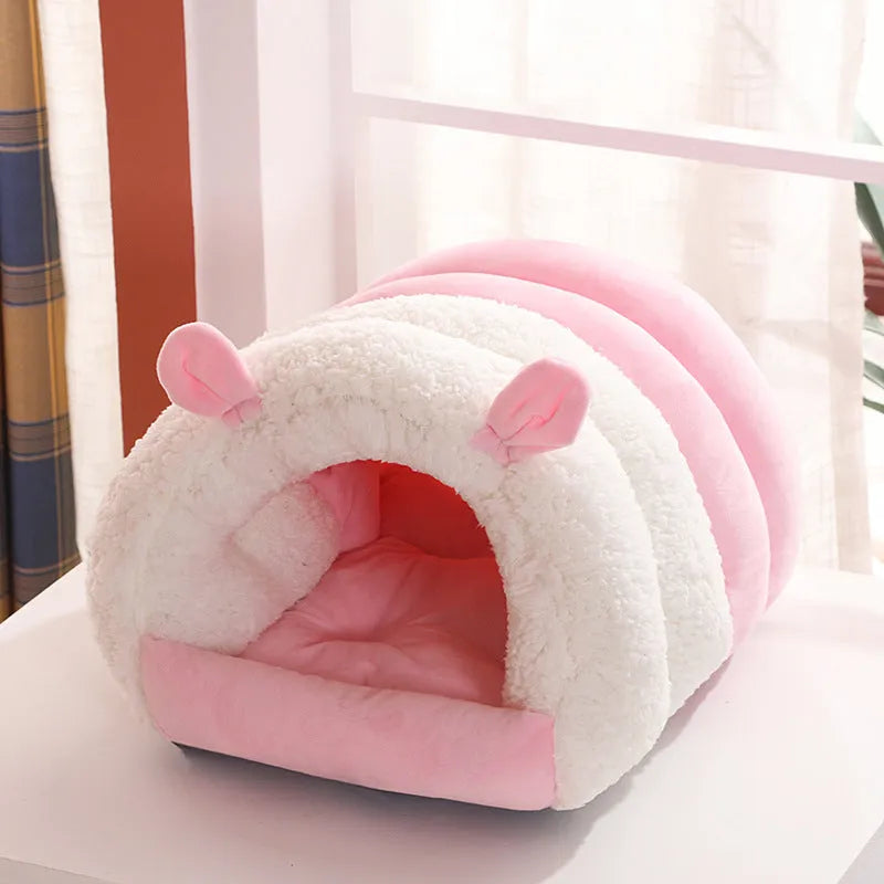 Blue enclosed cat bed with removable fleece liner, shown in a home setting.