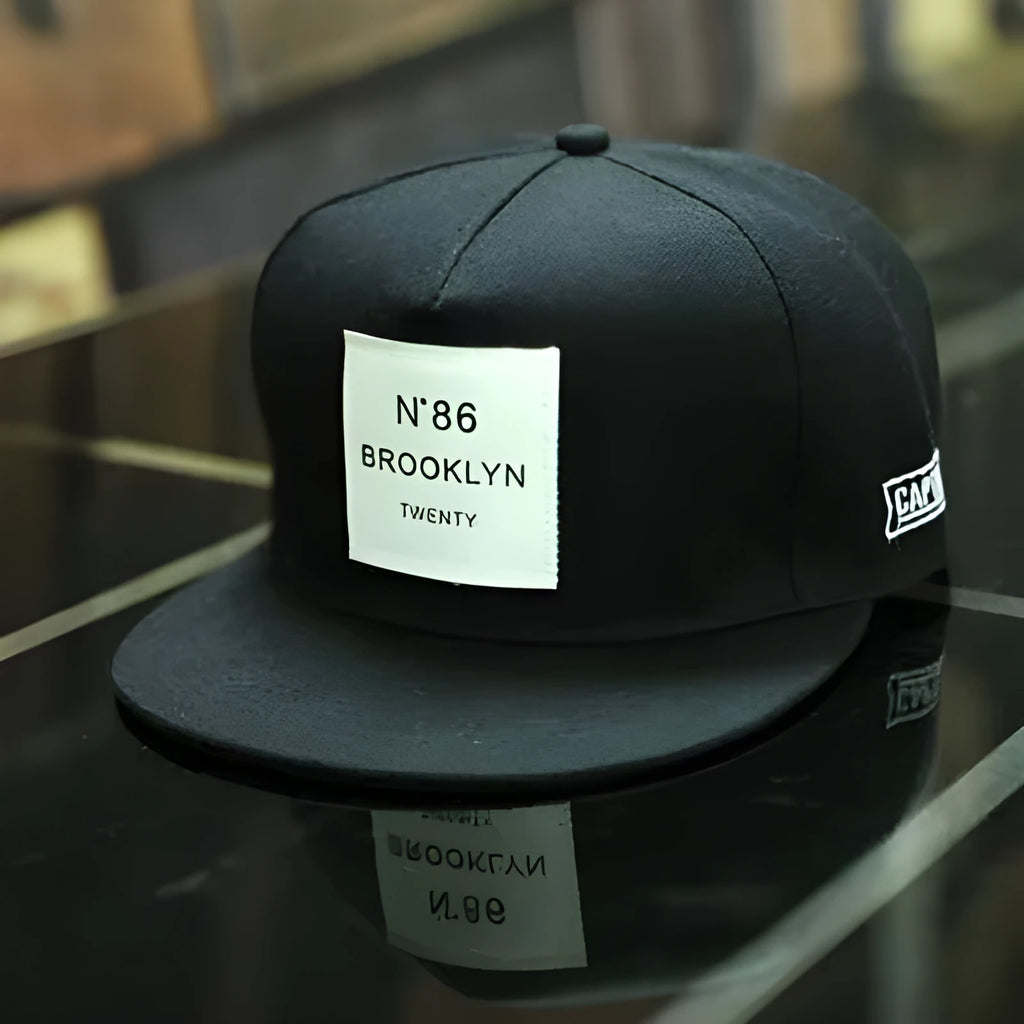 Leather snapback hat in black or white with adjustable fit, dome top, short brim, and curling eaves shape.