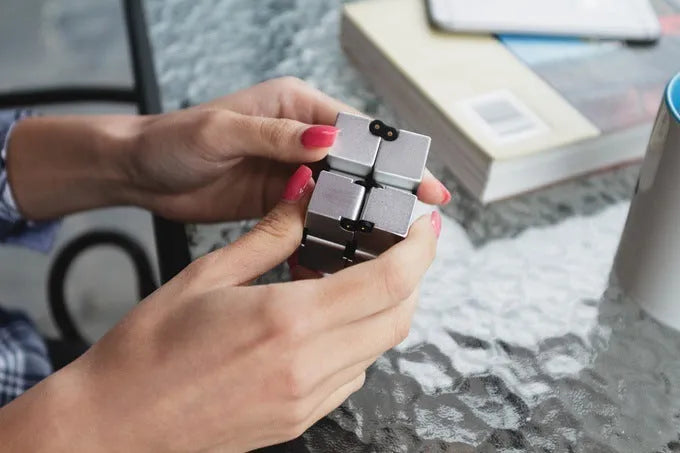 Zinc alloy infinity cube fidget toy in black or silver, showing rotating cubes on a 4cm scale.