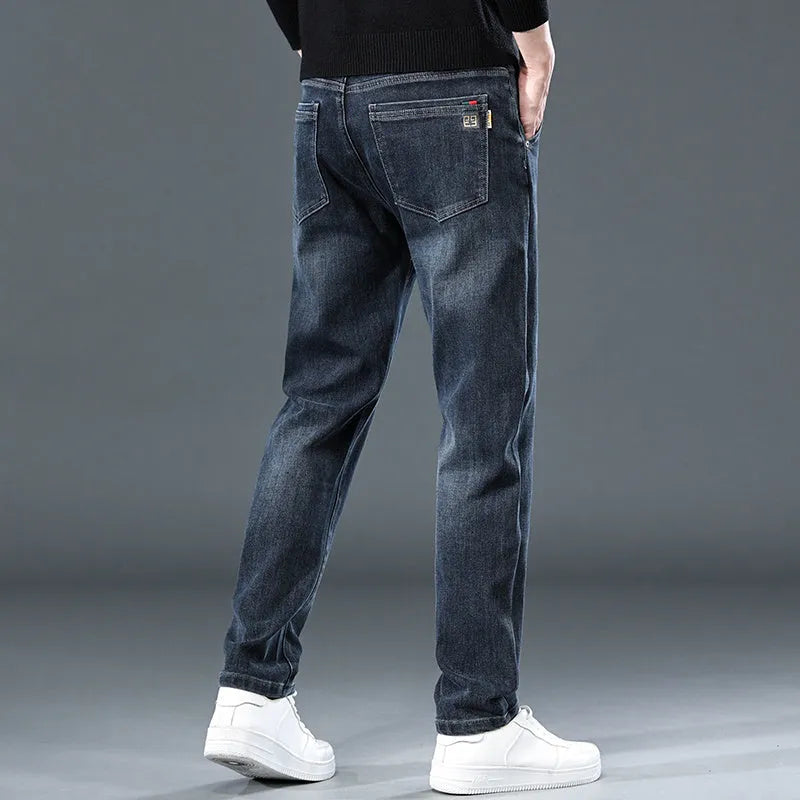 Blue grey men's slim straight casual trousers with a mid waist and zip fly on a neutral background.