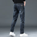 Blue grey men's slim straight casual trousers with a mid waist and zip fly on a neutral background.