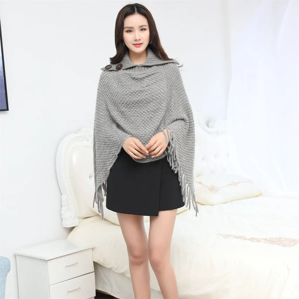 Sleeveless knitted cloak shawl with dot pattern, shown in apricot colour