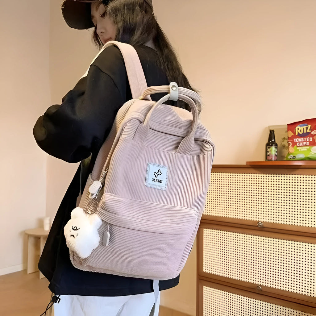 Retro hand-carrying backpack in light pink with breathable fabric, document pocket, and sewing line details for school use.
