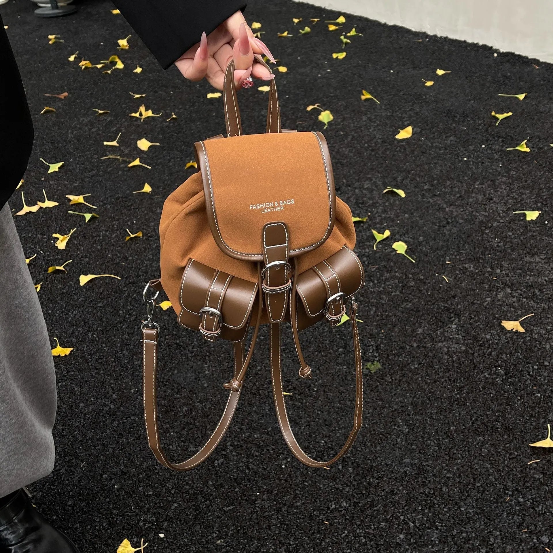 Urban simplicity PU backpack in brown with contrast stitching and clamshell opening, on a flat surface