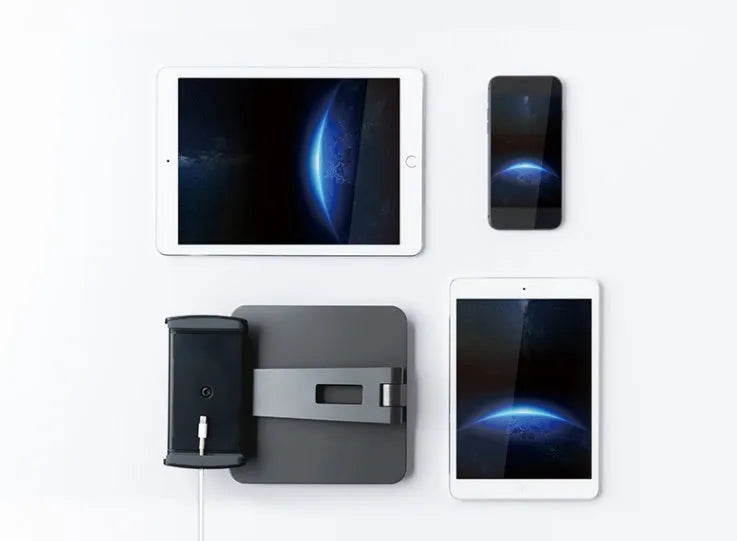 Silver foldable aluminium and ABS phone and tablet stand on a desk, showing 360-degree rotation.