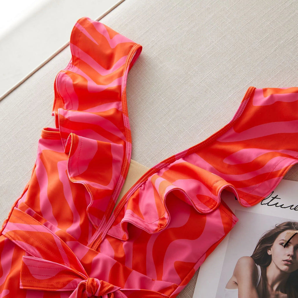 Women's one-piece swimsuit with double-shoulder ruffles, deep V-neck mesh stitching, and printed pattern.