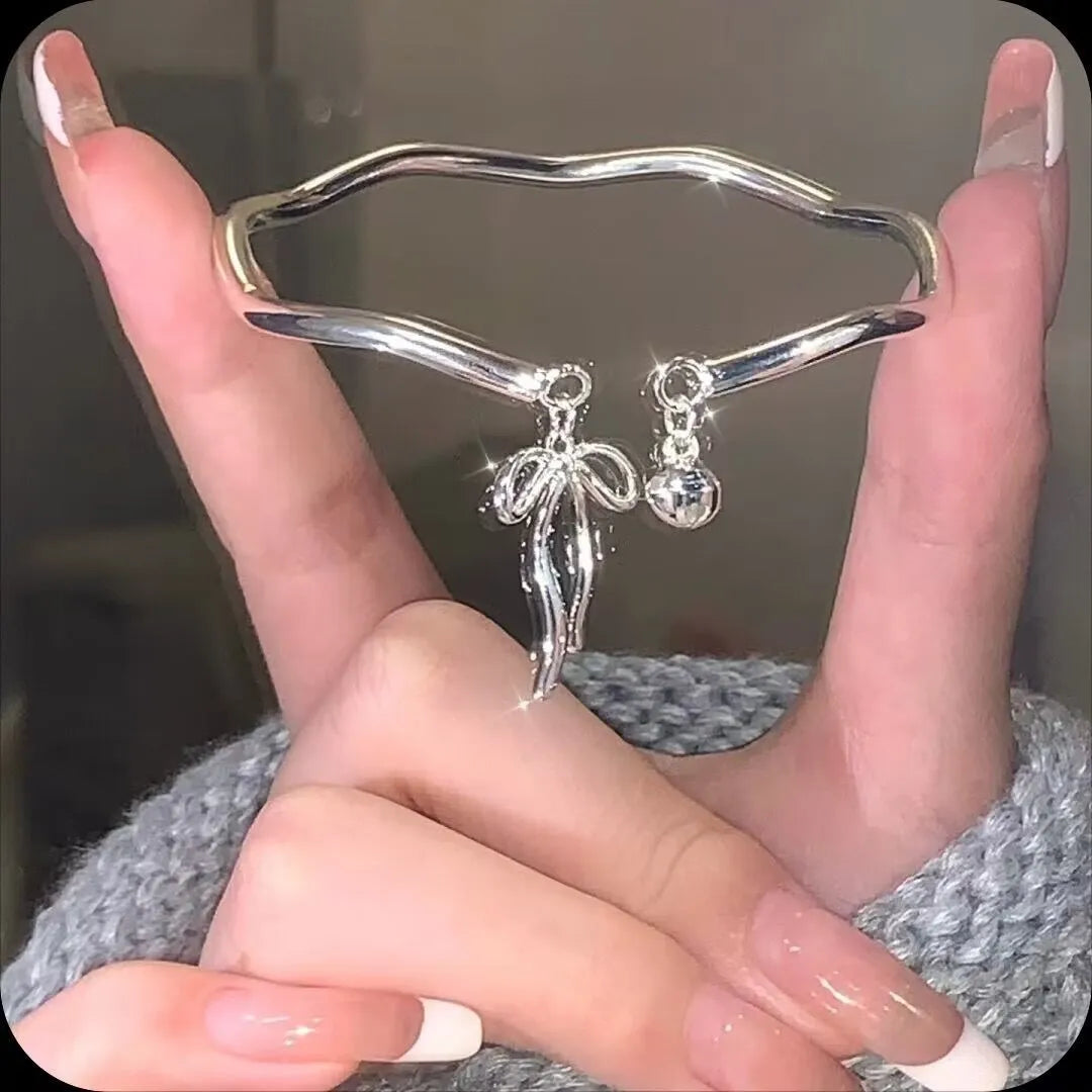 Silver-coloured adjustable bracelet for women featuring a bow charm and a sliding clasp.