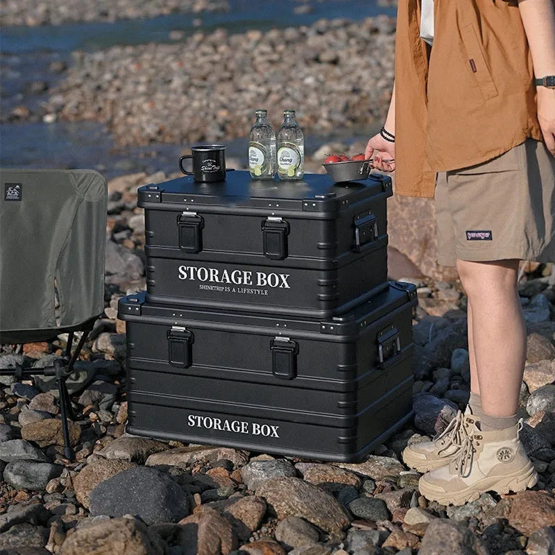 Army green waterproof storage box mounted in a vehicle cargo area.