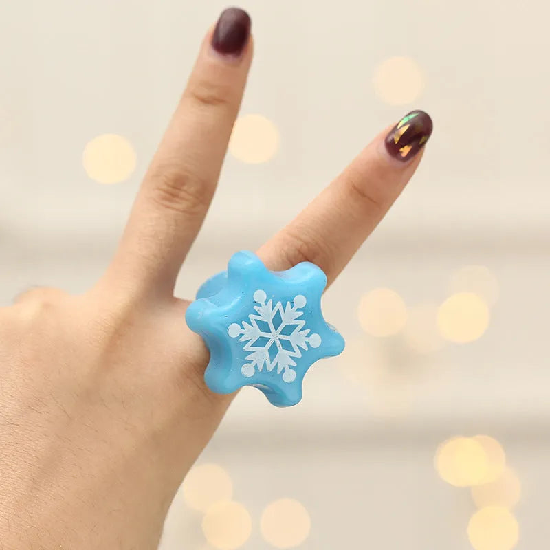 Set of four Christmas party finger lights with designs of small tree, elderly figure, snowflake, and snowman on display