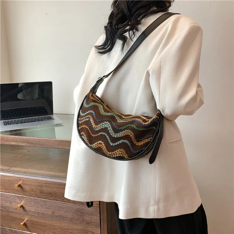 Women's woven straw crossbody bag showing knitted pattern and internal organisation compartments