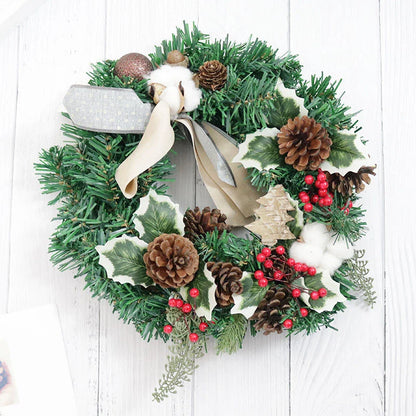 Festive Christmas wreath with artificial pine cones, berries, and maple leaves for elegant holiday decor