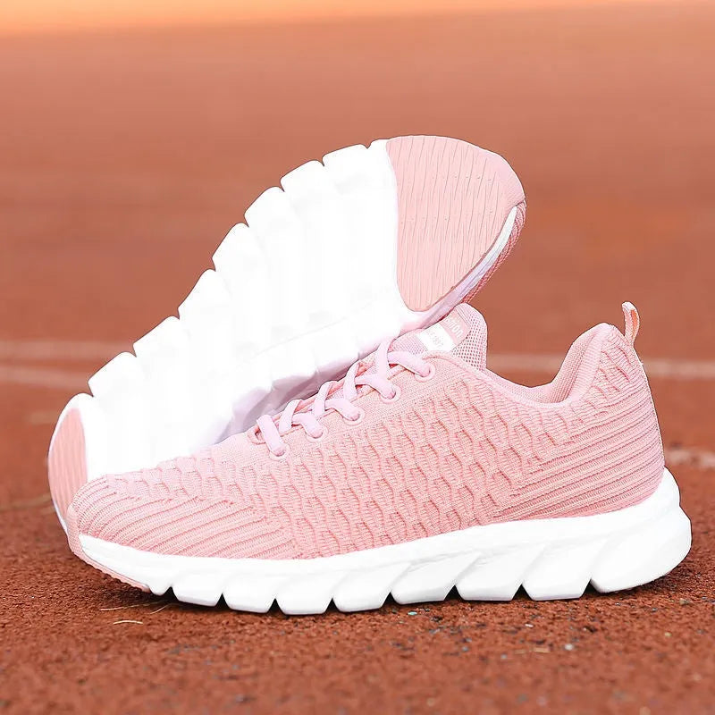 Women's running shoes in black, pink, and white with a fly weaving upper and wear-resistant outsole.