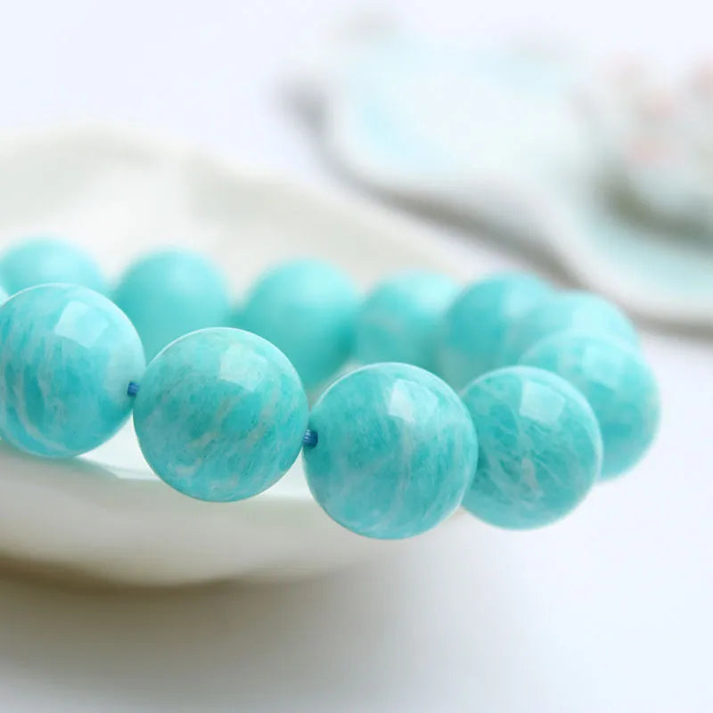 Natural blue-green amazonite gemstone beaded bracelet with stainless steel clasp on a wrist.