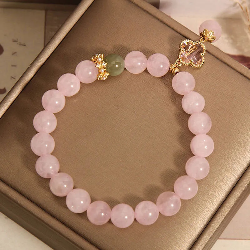 Pink crystal women's bracelet with a four-leaf clover pendant and sparkling rhinestone details.