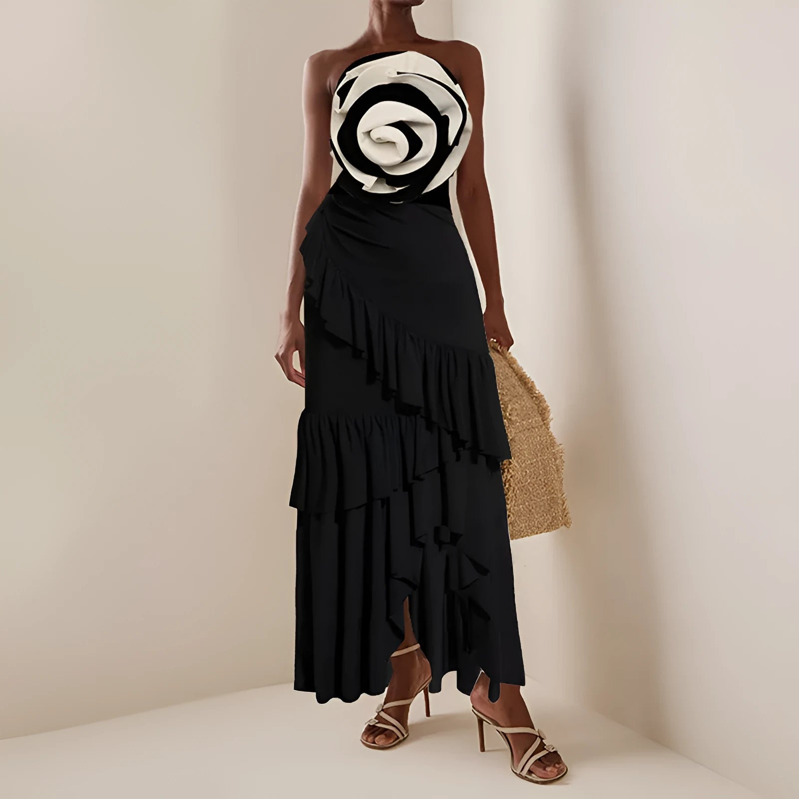 Women's black and white one-piece swimsuit with a detachable skirt laid flat on a beach towel.