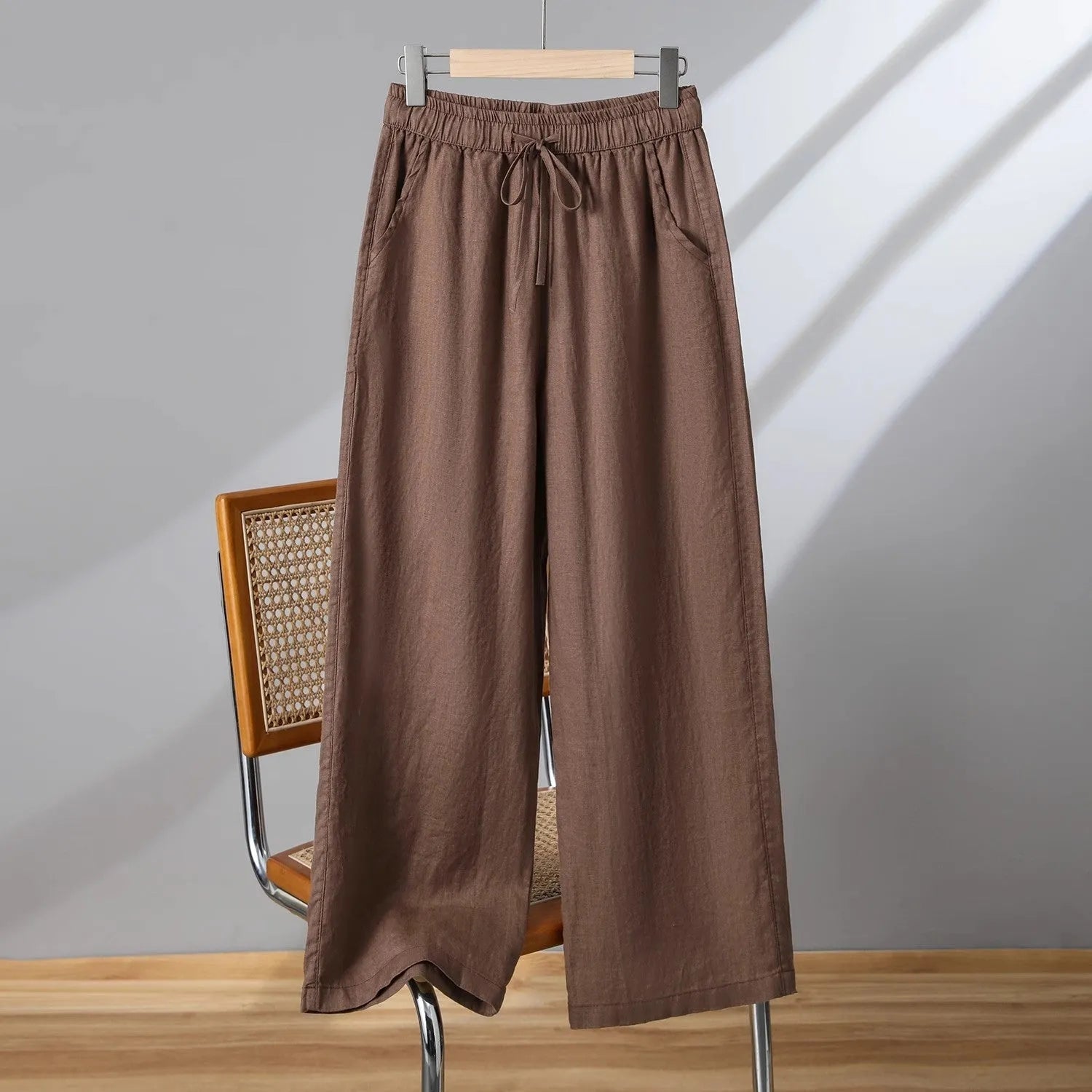Women's straight leg casual trousers in apricot colour with an elastic waistband and lace-up drawstring detail.