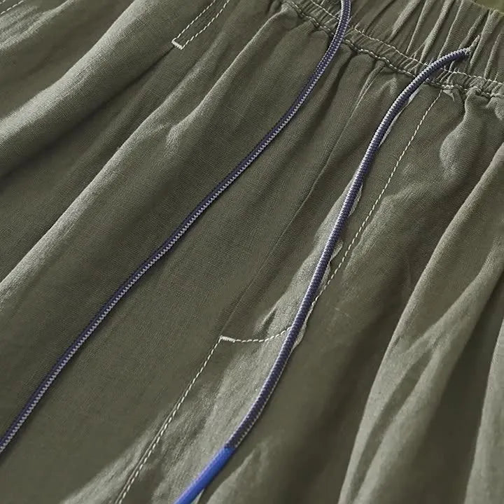 Men's green linen straight shorts with drawstring waist on hanger