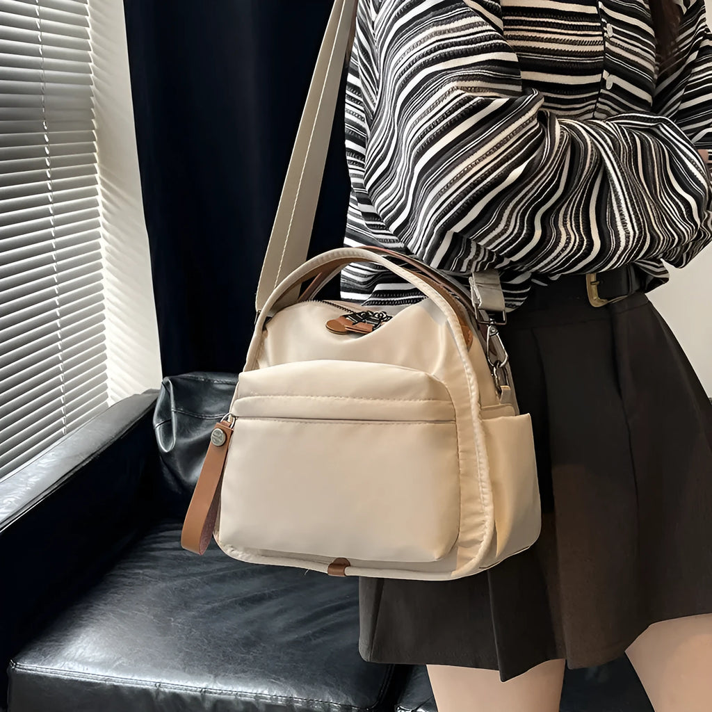 Nylon shoulder bag 25x11x23cm pillow shape with zippered compartment and outer pocket, available in brown, khaki, black, beige