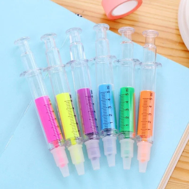 Six syringe-shaped fluorescent highlighter pens in assorted colours on a white background
