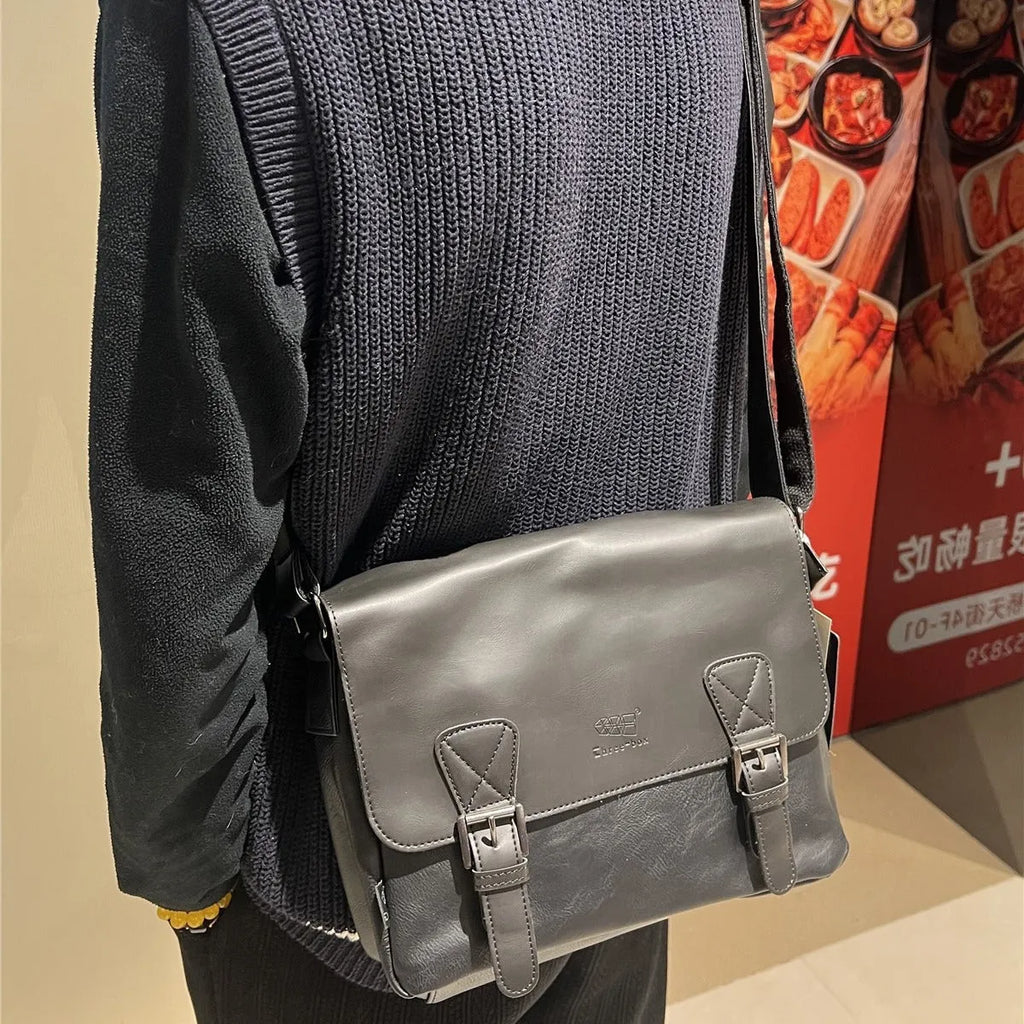 Retro men's messenger bag in light brown PU material with shoulder strap on neutral background