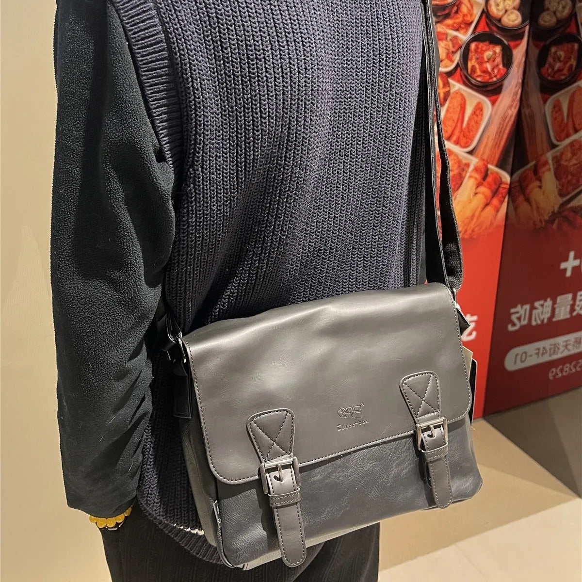 Retro men's messenger bag in light brown PU material with shoulder strap on neutral background