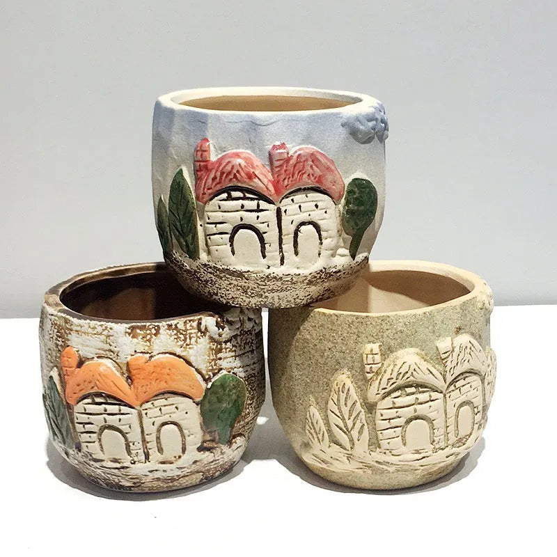 Three breathable stoneware succulent flower pots in hand-painted glaze colours on a tabletop with small succulents inside