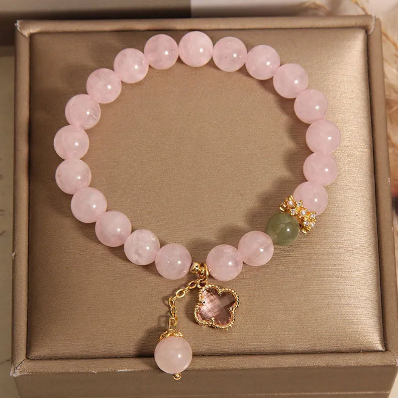 Pink crystal women's bracelet with a four-leaf clover pendant and sparkling rhinestone details.