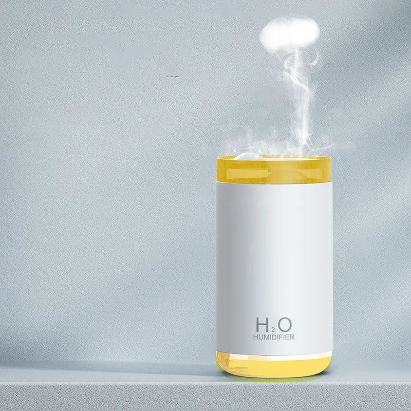 White USB humidifier emitting jellyfish-shaped smoke ring mist with warm night light glow on a table