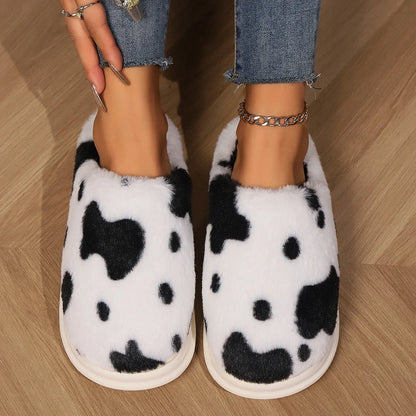 Cozy cow-print plush slippers with soft, fluffy material and non-slip soles for warm, comfortable indoor wear