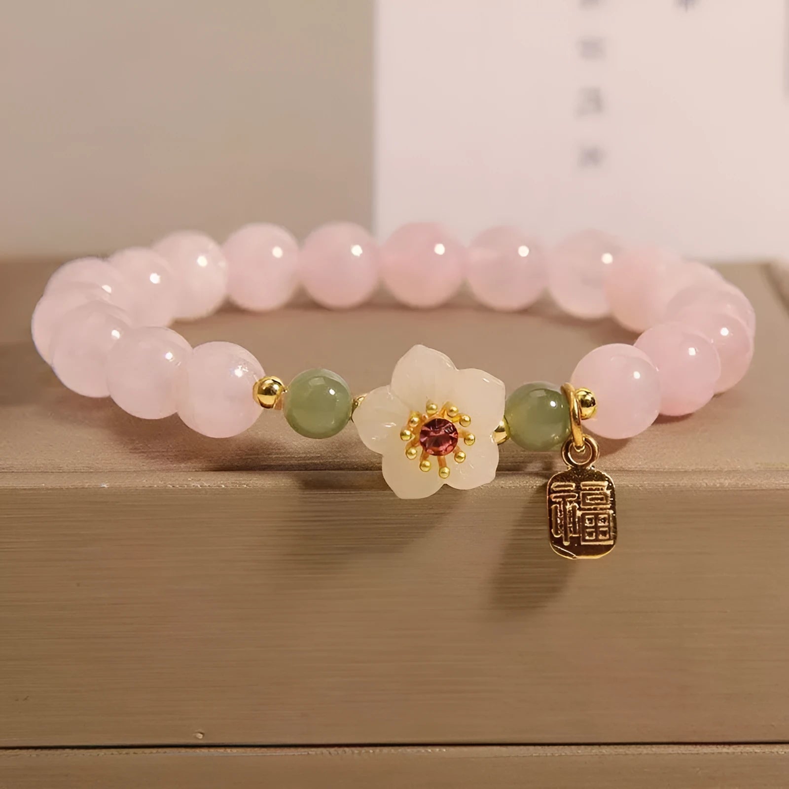 Crystal and Hetian Jade beaded bracelet with peach blossom design and adjustable cord.