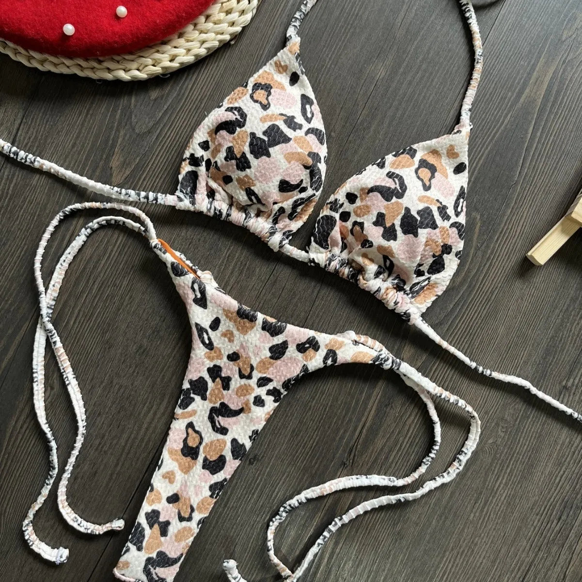 Women's printed bikini swimsuit on a hanger, showing briefs style with quick-drying fabric and cotton lining.