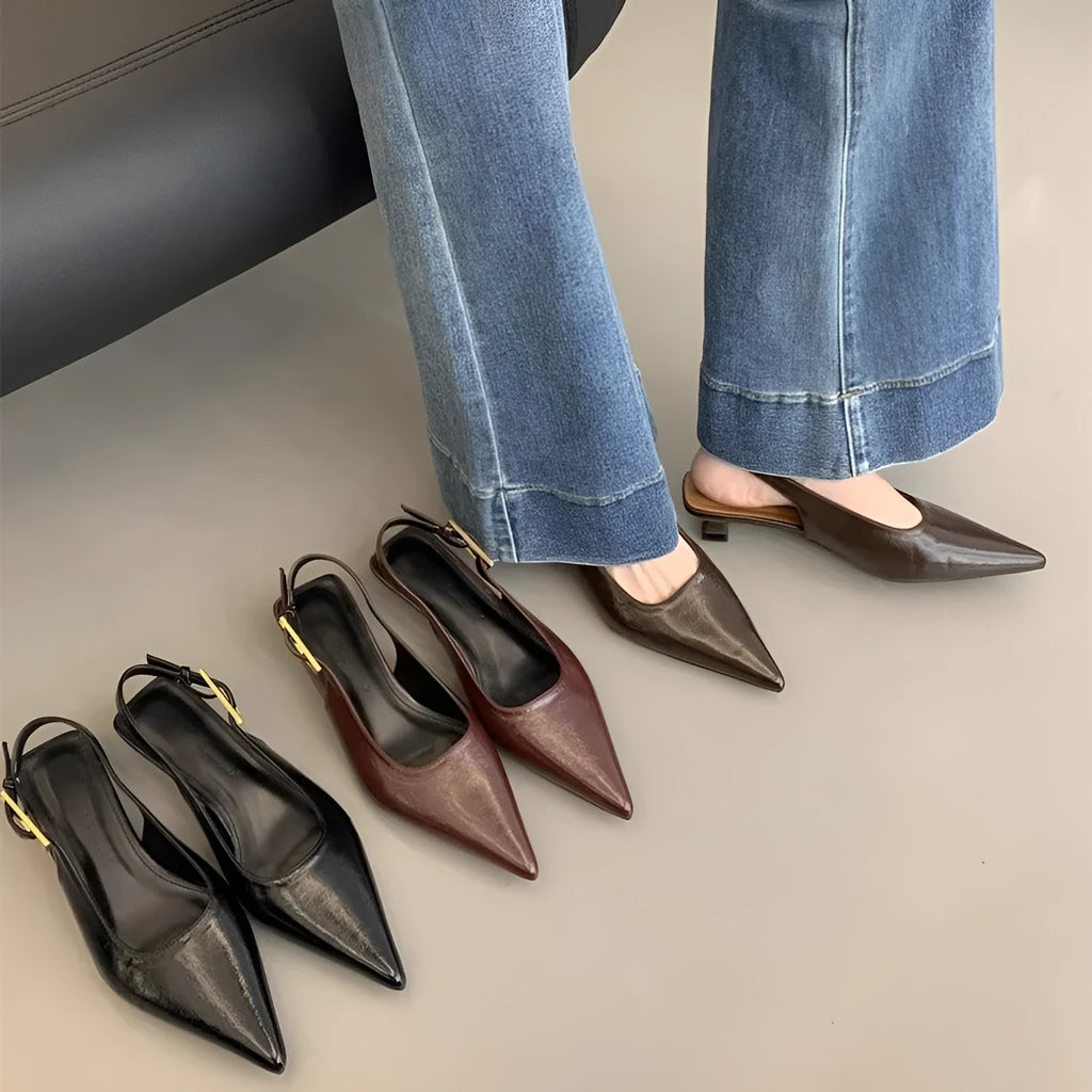 Black pointed toe low heel women's shoes with an ankle strap and rubber sole.