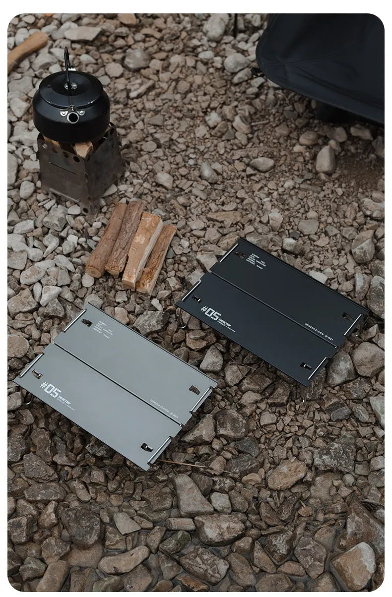 Aluminium alloy camping folding table shown in a folded position, available in black or grey colour.