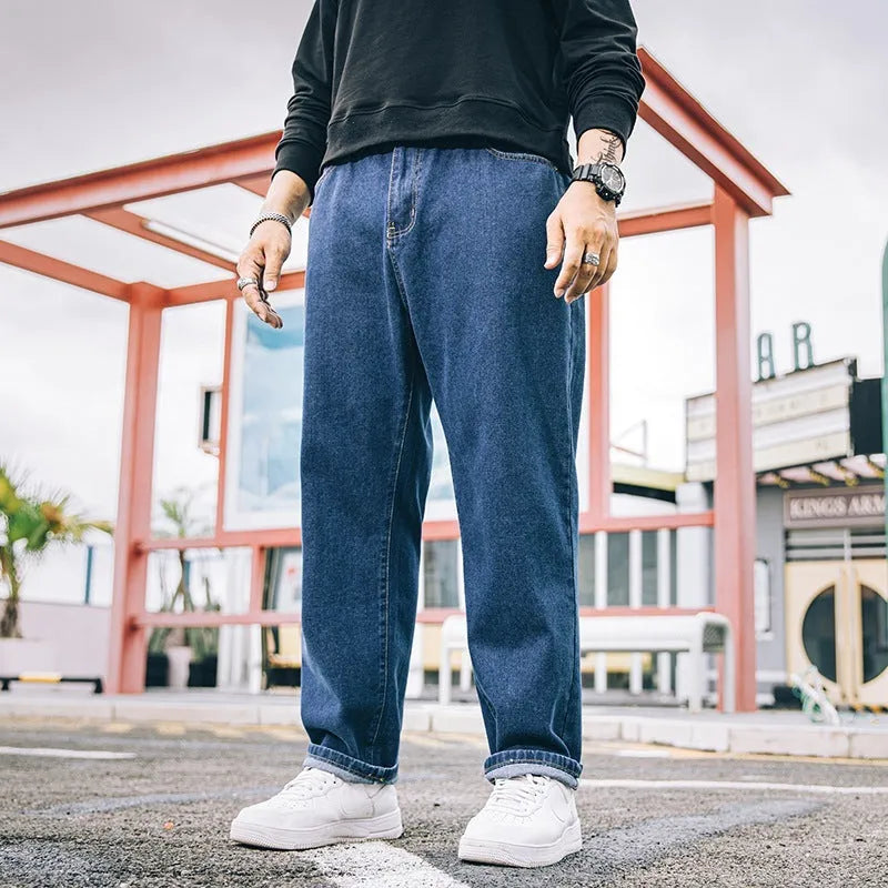 Men's loose straight-cut cotton jeans in dark blue, shown in a casual setting